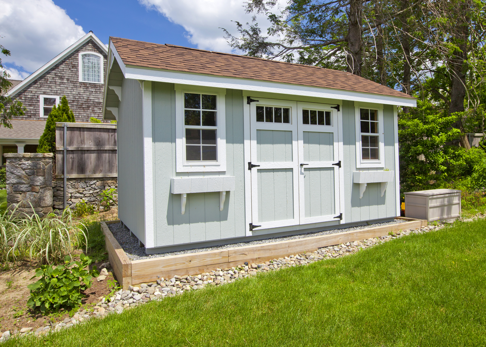 New blue garden shed in beautiful garden