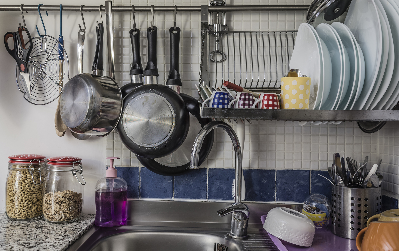 Plates and cups left to dry on a iron dish rack