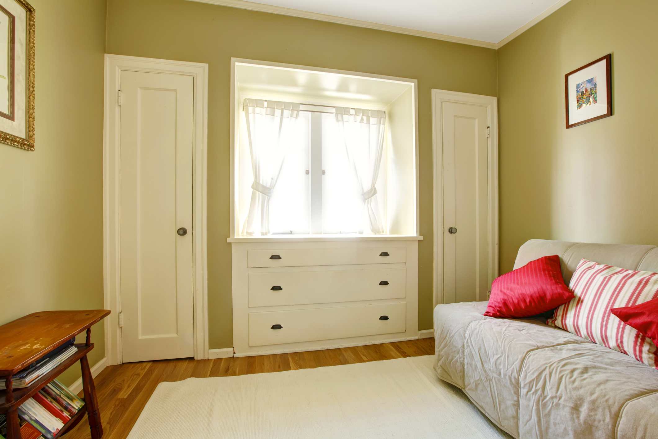 Green bedroom with white doors and dresser
