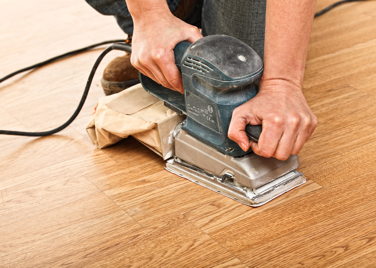 Carpenter use sander on wood floor