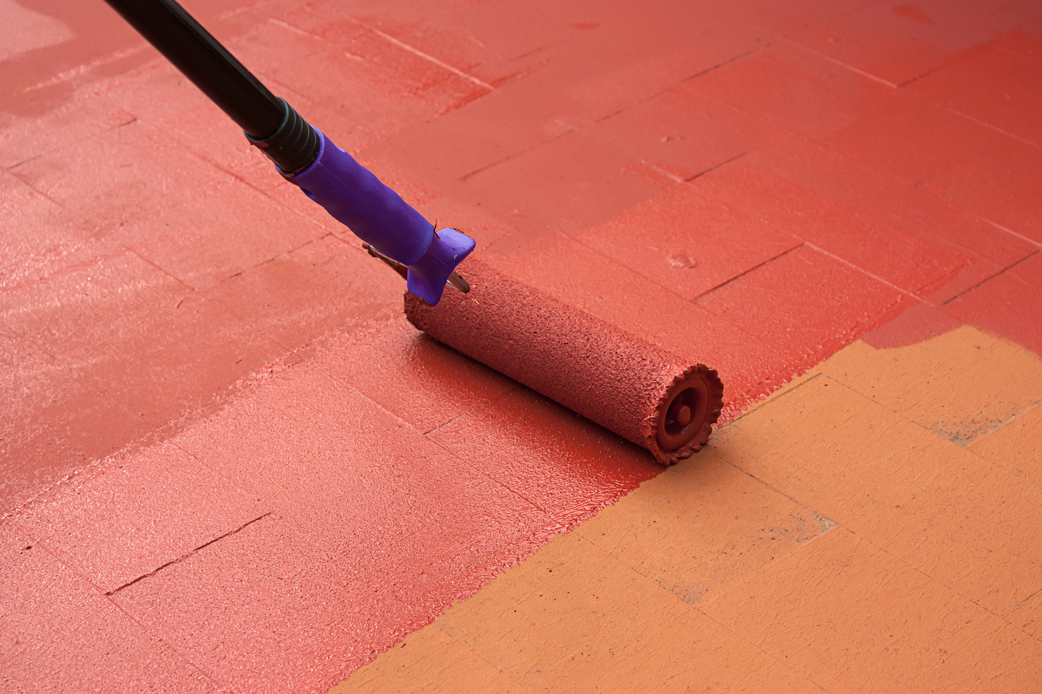 Painter painting a floor on color red