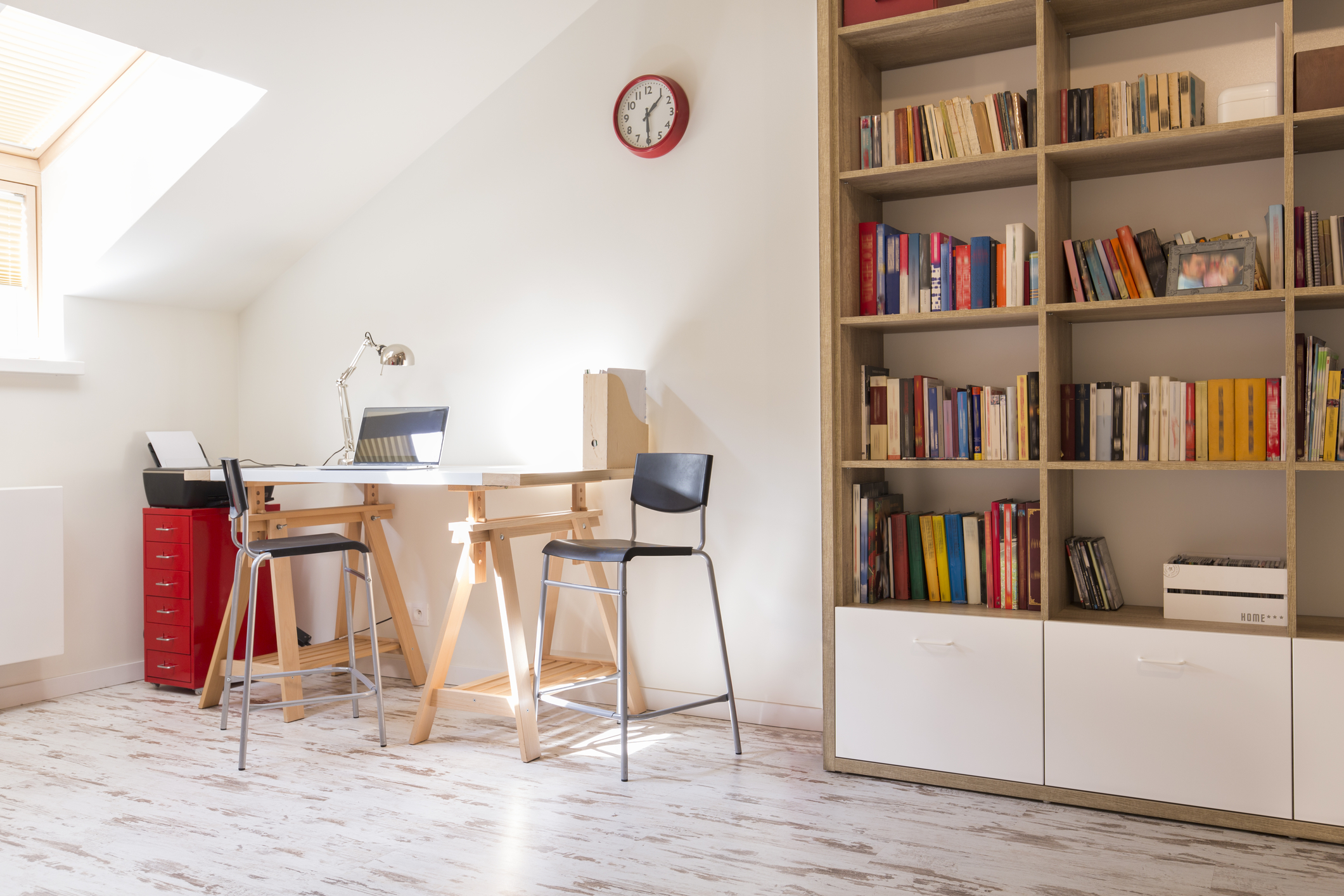 Shot of a modern study with a desk and a bookshelf.